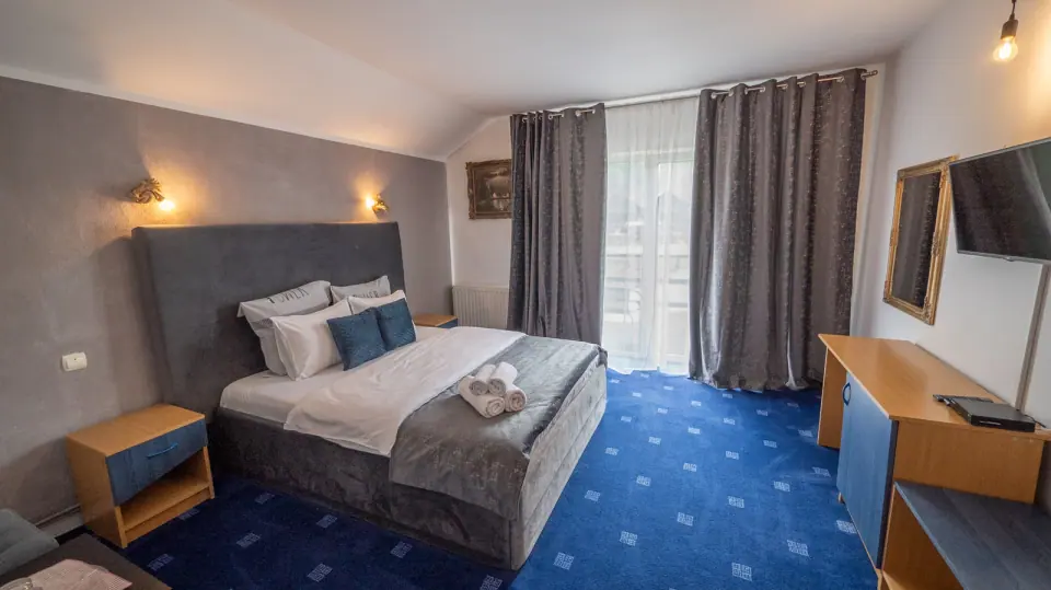 Double bedroom with blue carpet beside the balcony