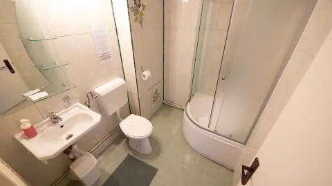 White bathroom with a shower enclosure, basin and toilet