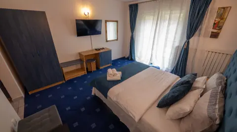 Double bed, television and furniture in the blue room