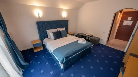 Double bed and wardrobe in the blue-carpeted room