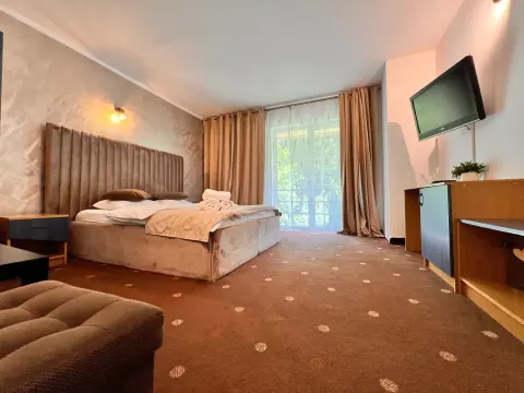 Double bedroom with armchairs and a balcony in warm tones