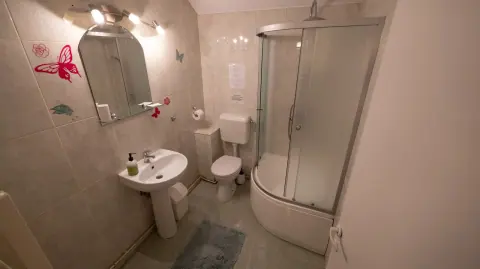 Bathroom with shower, basin, mirror and toilet