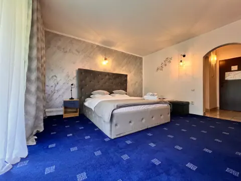 Double bed with a grey headboard and blue carpet