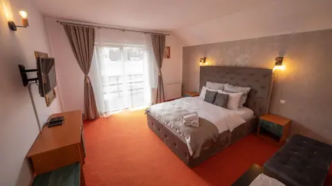 Double bedroom with orange carpet and a balcony