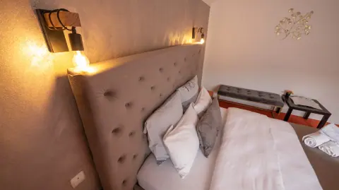 Bed with a grey headboard and warm room lighting