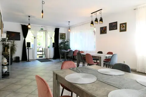 Guesthouse dining room with tables, chairs and plants
